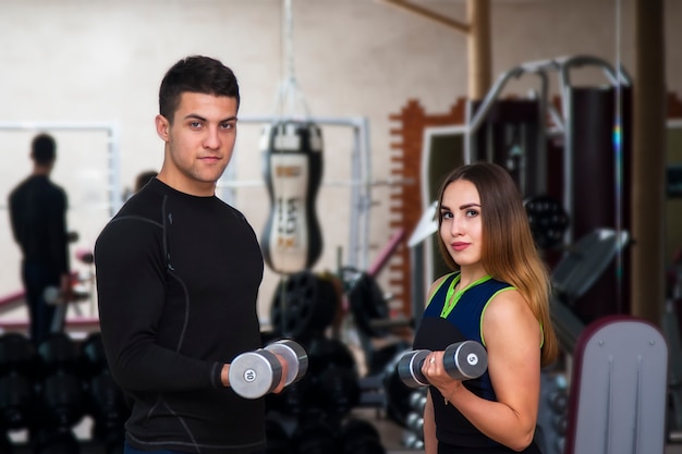 Athletisches Mädchen und Kerl der glücklichen Süsse, Übung mit Dummköpfen