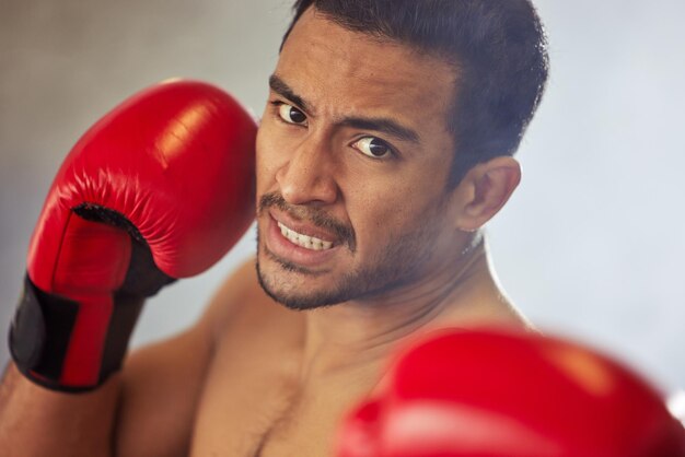 Atingindo rapidamente o retrato recortado de um belo jovem boxeador masculino atacando a câmera durante uma luta no ringue