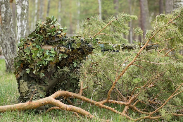 Atirador furtivo camuflado na floresta em emboscada. militar apontando uma  arma, um rifle para o inimigo na natureza. exército, airsoft, hobby,  conceito de jogo