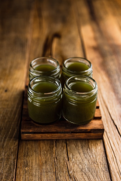 Atiradores alcoólicos de cor verde ou bebidas na mesa de madeira