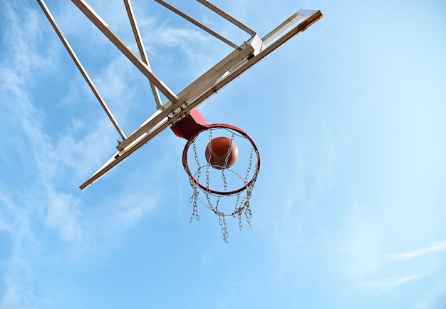 Atirando uma bola de basquete laranja para a cesta