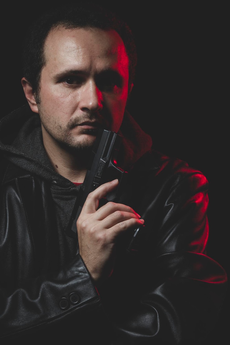 Foto atire, homem com intenção de cometer suicídio, arma e jaqueta de couro, luz de fundo vermelha