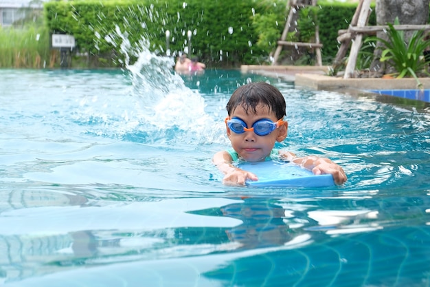 Atividades asiáticas de meninos fofos na piscina