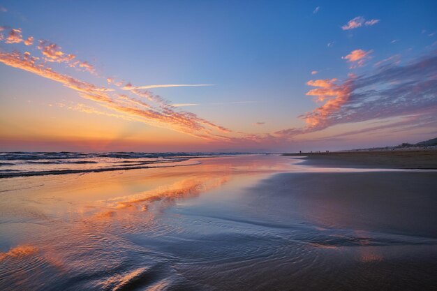 Atlantischer Ozeansonnenuntergang mit wogenden Wellen am Strand von Fonte da Telha in Portugal