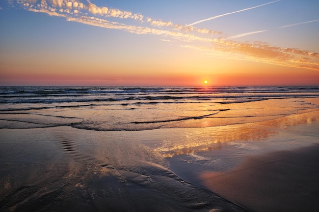 Atlantischer Ozeansonnenuntergang mit wogenden Wellen am Strand von Fonte da Telha in Portugal