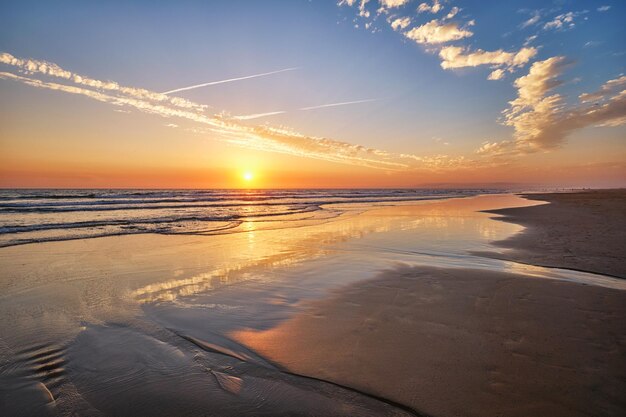 Atlantischer Ozeansonnenuntergang mit wogenden Wellen am Strand von Fonte da Telha in Portugal