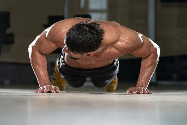 Foto atleta adulto haciendo flexiones como parte del entrenamiento crossfit