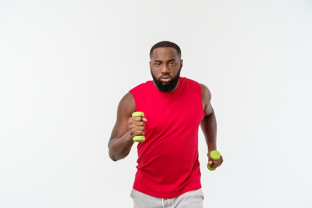 Atleta afro-americano novo holding lifting dumbbells no branco isolado.