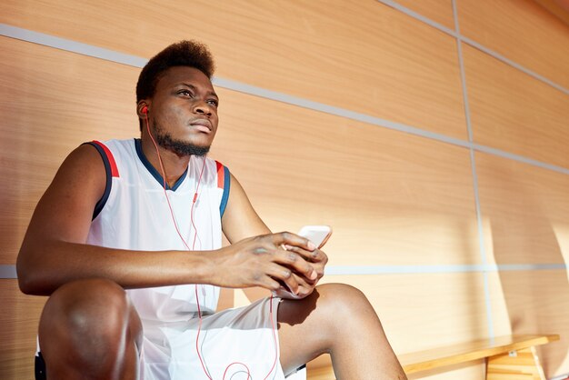 Atleta afroamericano escuchando música en el gimnasio