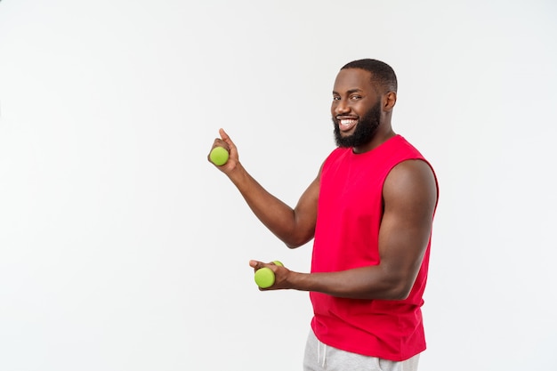 Atleta afroamericano joven Holding Lifting Dumbbells en blanco aislado.