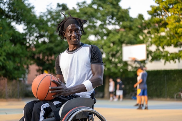 Atleta afroamericano en silla de ruedas jugando baloncesto concepto de discapacidad deportiva