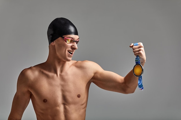 Atleta alegre nadador com uma medalha nas mãos emoções positivas alegria da vitória o conceito de sucesso nunca desista e você alcançará o sucesso