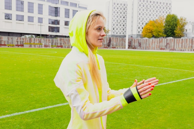 Una atleta antes de entrenar Una joven se estira usando una banda elástica en un estadio al aire libre