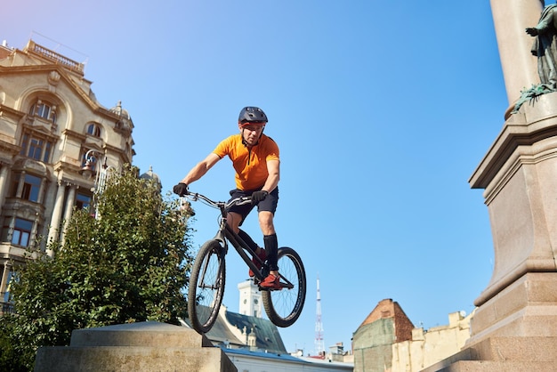 Atleta con bicicleta en las manos y mirando hacia otro lado