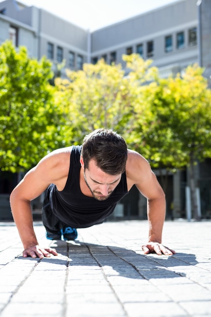 Atleta bonito fazendo flexões no chão