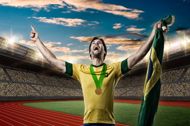 Atleta brasileño ganando una medalla de oro en un estadio de pista y campo.