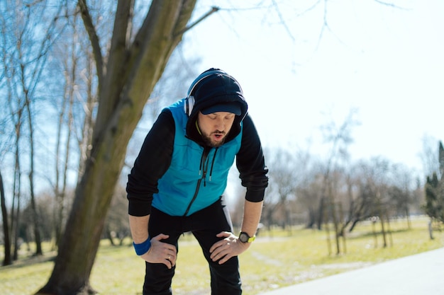 Un atleta cansado después de correr unos kilómetros por el parque