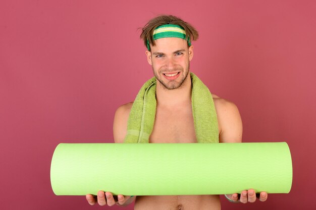 Atleta con cara sonriente se prepara para hacer yoga