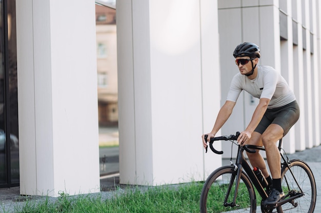 Atleta caucasiano vestindo capacete de roupas esportivas e óculos tendo treino intenso no ar fresco conceito de pessoas e ciclismo