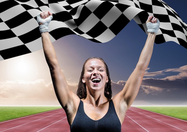 Foto atleta comemorando sua vitória com bandeira quadriculada na pista de corrida