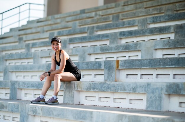 Atleta corredor al aire libre de mujer asiática hermosa de mediana edad que se ejecuta en las escaleras del estadio estilo de vida activo y saludable.