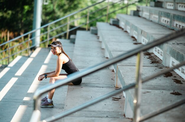 Foto atleta corredor al aire libre de mujer asiática hermosa de mediana edad que se ejecuta en las escaleras del estadio estilo de vida activo y saludable.