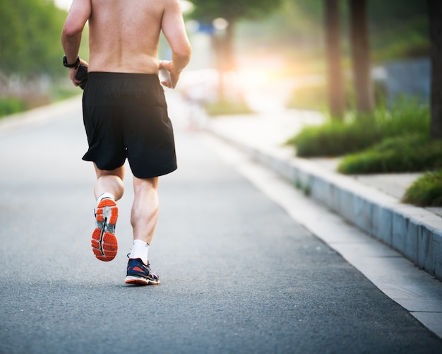 Atleta corredor corriendo en carretera. Mujer fitness amanecer trotar entrenamiento concepto de bienestar.