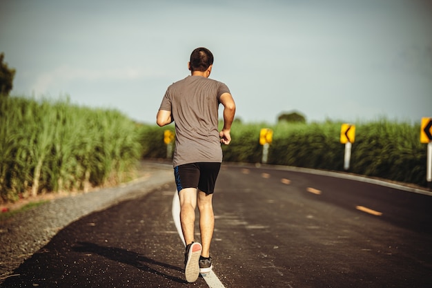 Atleta corredor hombre en el camino hacia la salud, los jóvenes ejecutan ejercicio en la calle