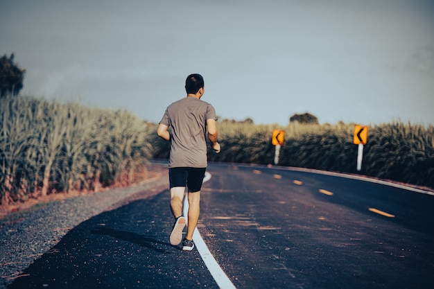 Atleta corredor hombre en el camino hacia la salud, los jóvenes ejecutan ejercicio en la calle