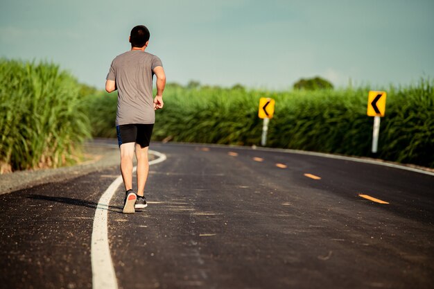 Atleta corredor homem na estrada para jovens saudáveis, executando exercícios na rua