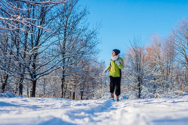 Atleta correndo correndo na floresta de inverno treinando ao ar livre em clima frio e nevado