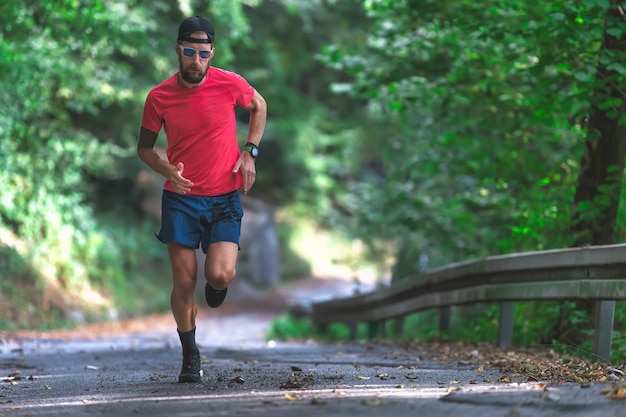 Un atleta corriendo por una carretera asfaltada cuesta arriba