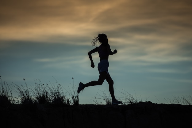 Atleta de corredor correndo na trilha. mulher fitness jogging conceito de bem-estar de treino.