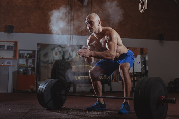 Atleta de crossfit masculino forte exercitar com barra pesada