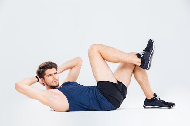 Atleta de jovem bonito malhando e fazendo abdominais