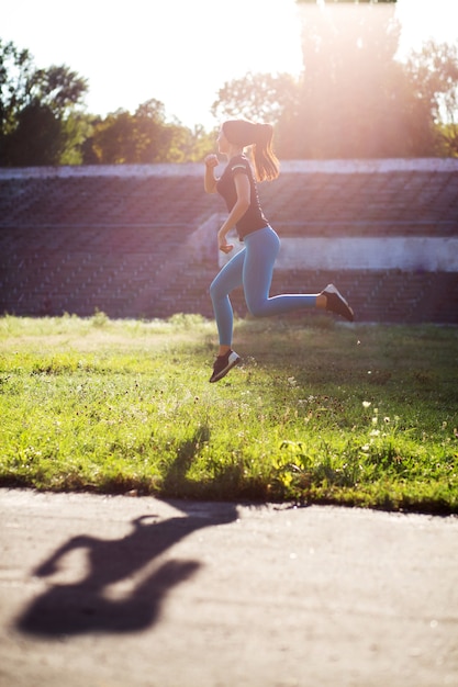 Atleta de modelo deslumbrante em roupas esportivas, saltando durante o treino. Espaço para texto