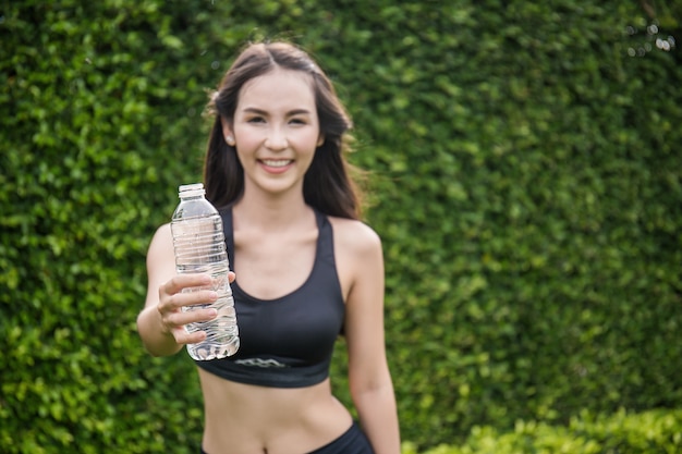 Atleta de mulher asiática segurando a garrafa de água