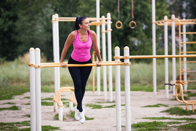 atleta de mulher envolvida na barra horizontal na rua