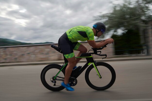 Foto atleta de triatlo a andar de bicicleta no treino da manhã