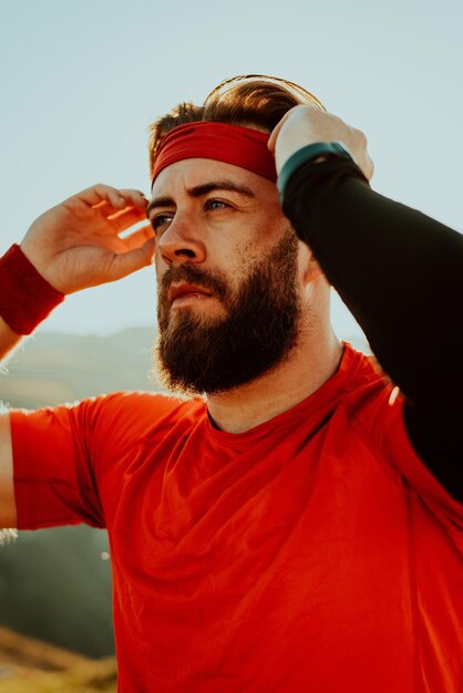 Un atleta decidido preparándose para el inicio del entrenamiento en la cima de la montaña al amanecer.