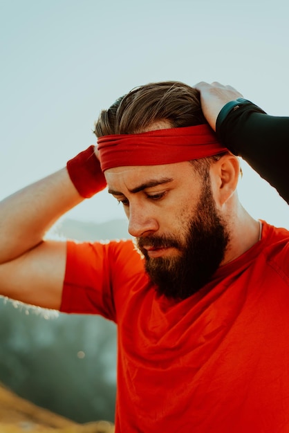 Un atleta decidido preparándose para el inicio del entrenamiento en la cima de la montaña al amanecer.