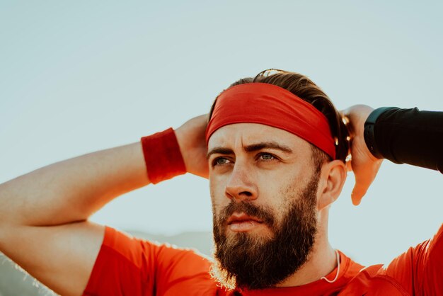 Un atleta decidido preparándose para el inicio del entrenamiento en la cima de la montaña al amanecer.