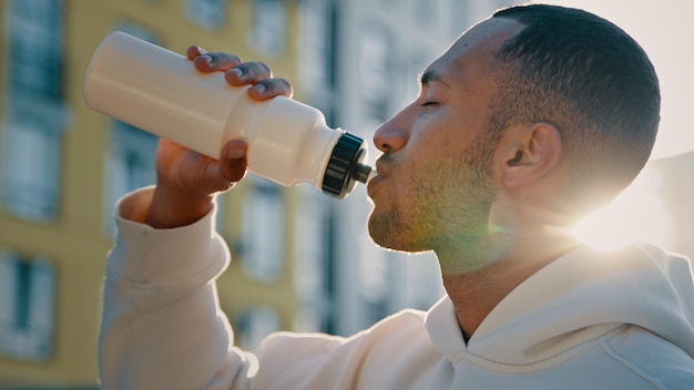 Atleta deportista latina hombre guapo hombre afroamericano hombre corredor culturista beber agua fría y dulce