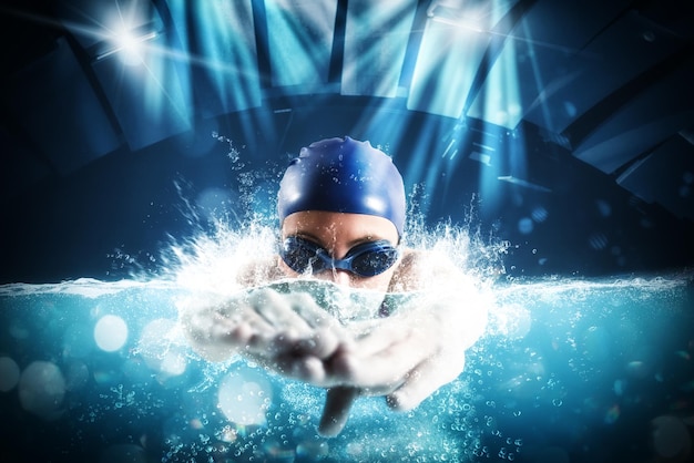 Foto atleta deportiva mujer nada con energía durante una competencia en la piscina