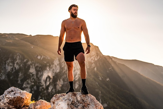 Un atleta descansa en la cima de una montaña después de un agotador entrenamiento de carrera