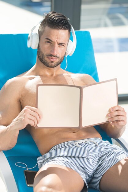 Atleta descansando na espreguiçadeira e ouvindo música