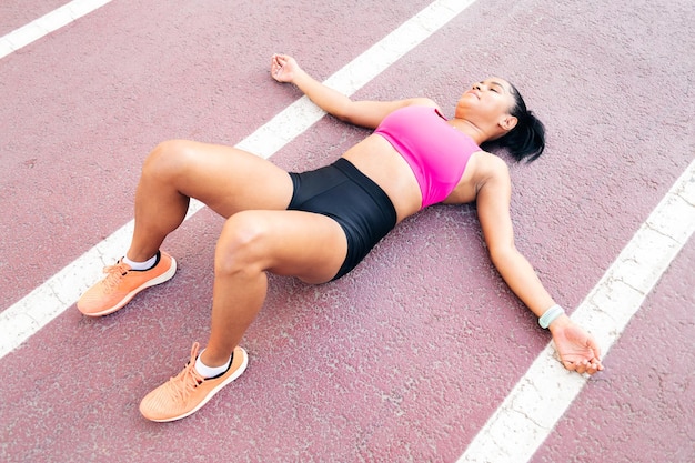 Atleta descansando en la pista de atletismo después del entrenamiento