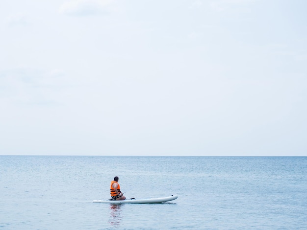 Un atleta se entrena en una tabla, nada en el mar y remo, surfea en una tablilla de surf como pasatiempo.