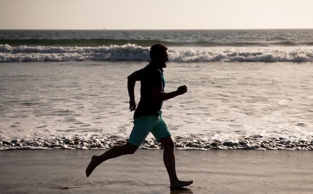 Atleta esportivo corre rápido para ganhar na atividade de treino matinal do oceano homem saudável correndo na praia