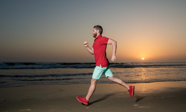 Atleta esportivo corre rápido para vencer na atividade de treino matinal do pôr do sol do mar homem saudável correndo